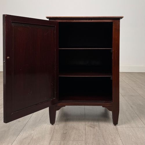 fig 1. A dark stained oak Edwardian cupboard featuring a single panel door, teardrop handle, and square tapered legs.