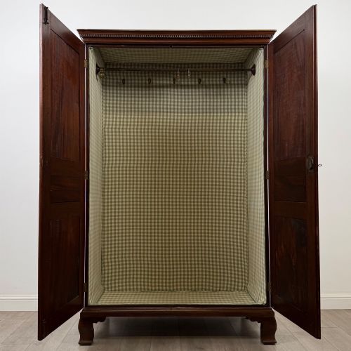fig 1. An 18th-century Georgian mahogany two-door wardrobe featuring fielded panel doors, a dentil-moulded cornice, and shaped bracket feet.