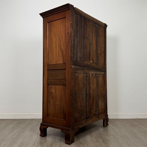 fig 4. An 18th-century Georgian mahogany two-door wardrobe featuring fielded panel doors, a dentil-moulded cornice, and shaped bracket feet.