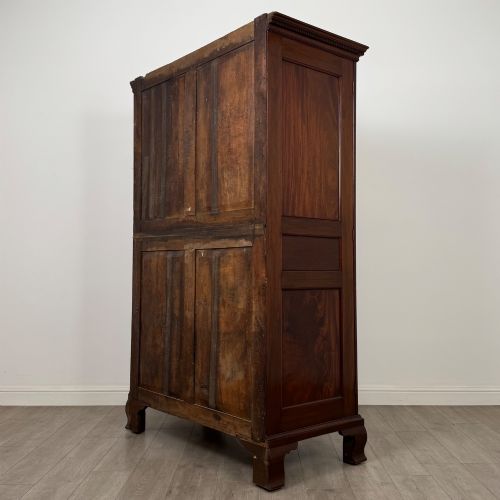 fig 6. An 18th-century Georgian mahogany two-door wardrobe featuring fielded panel doors, a dentil-moulded cornice, and shaped bracket feet.