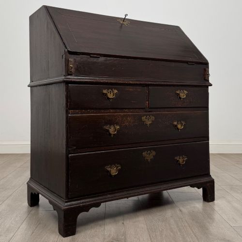 fig 8. An 18th-century dark oak Georgian bureau with a slant-front writing slope, brass batwing drop handles, and bracket feet.