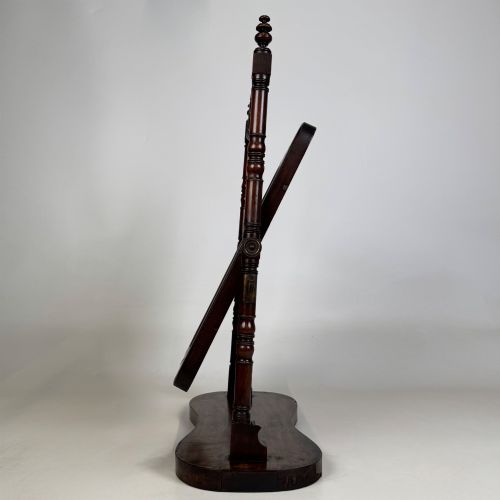 fig 4. A 19th-century mahogany dressing mirror with turned side columns, carved scrollwork cresting, and an adjustable rectangular glass frame on a shaped base.
