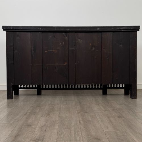 fig 6. An antique ebonised black wood sideboard featuring a central open bookshelf, two carved side doors with glass panels, brass hardware, and a spindled lower rail.