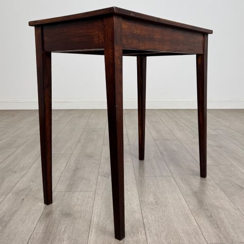 fig 3. An antique dark oak Edwardian side table with two front drawers, metallic drop handles, and straight tapered legs.