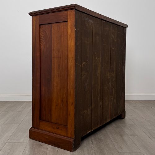 fig 3. An Edwardian walnut chest of drawers featuring a two over three drawer layout with brass drop handles and a solid plinth base.