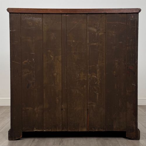 fig 4. An Edwardian walnut chest of drawers featuring a two over three drawer layout with brass drop handles and a solid plinth base.