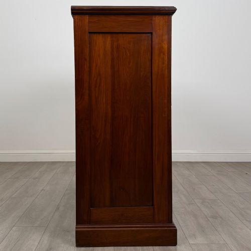 fig 6. An Edwardian walnut chest of drawers featuring a two over three drawer layout with brass drop handles and a solid plinth base.