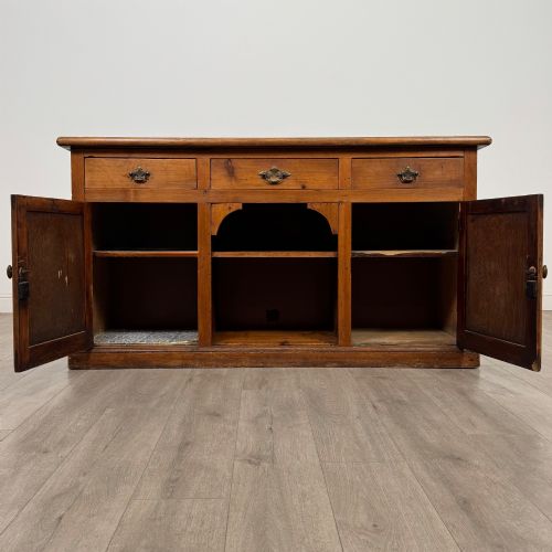 fig 1. A 19th-century pine farmhouse dresser base featuring three upper drawers above two cupboard doors and an open central shelf.