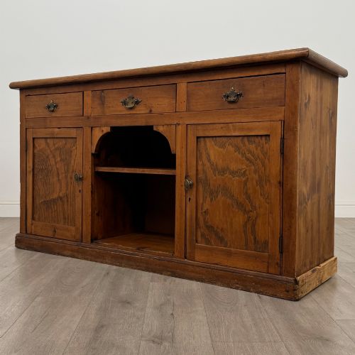 fig 2. A 19th-century pine farmhouse dresser base featuring three upper drawers above two cupboard doors and an open central shelf.