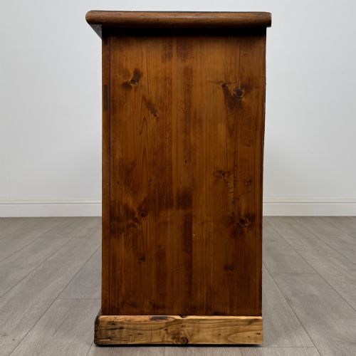 fig 3. A 19th-century pine farmhouse dresser base featuring three upper drawers above two cupboard doors and an open central shelf.