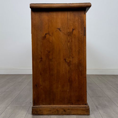 fig 7. A 19th-century pine farmhouse dresser base featuring three upper drawers above two cupboard doors and an open central shelf.