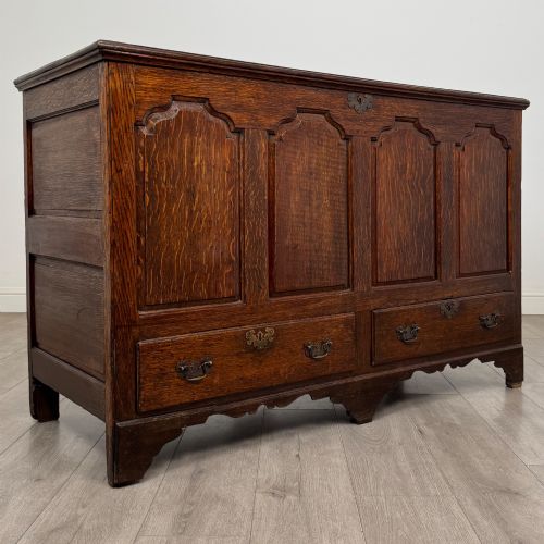 fig 7. An 18th-century Georgian oak mule chest featuring four arched fielded panels, two base drawers with brass hardware, and a shaped apron.
