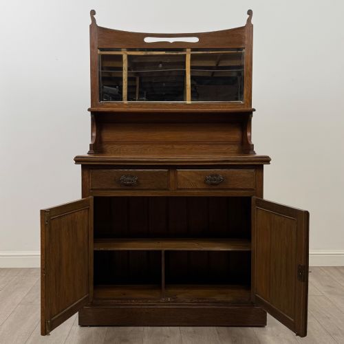 fig 1. An early 20th-century warm brown oak mirror back sideboard featuring two drawers, a double-door cupboard base, and an elevated mirror plate cresting.