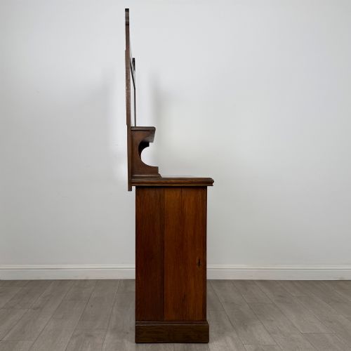 fig 7. An early 20th-century warm brown oak mirror back sideboard featuring two drawers, a double-door cupboard base, and an elevated mirror plate cresting.