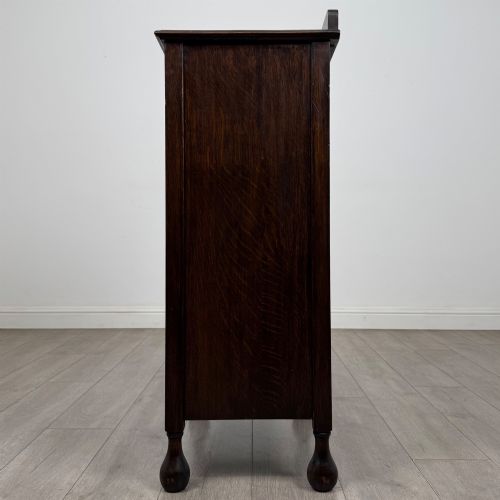 fig 3. An Edwardian dark brown oak display cabinet featuring a single glazed door and turned feet.