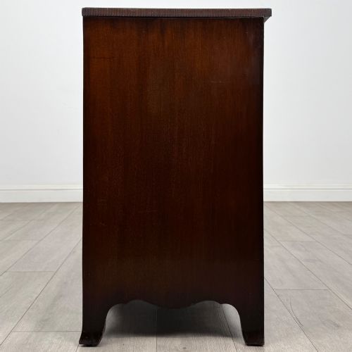 fig 2. A mahogany serpentine chest of drawers featuring four graduating drawer tiers with brass handles and a curved front profile.