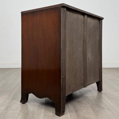 fig 3. A mahogany serpentine chest of drawers featuring four graduating drawer tiers with brass handles and a curved front profile.