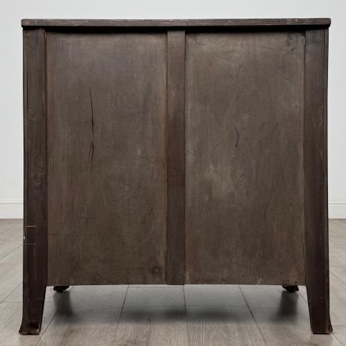 fig 4. A mahogany serpentine chest of drawers featuring four graduating drawer tiers with brass handles and a curved front profile.