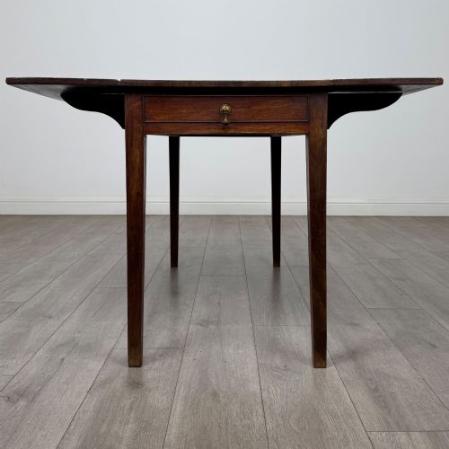 fig 4. A 19th-century Georgian style dark mahogany Pembroke side table with drop leaves, tapered square legs, and a single frieze drawer with a brass drop handle.
