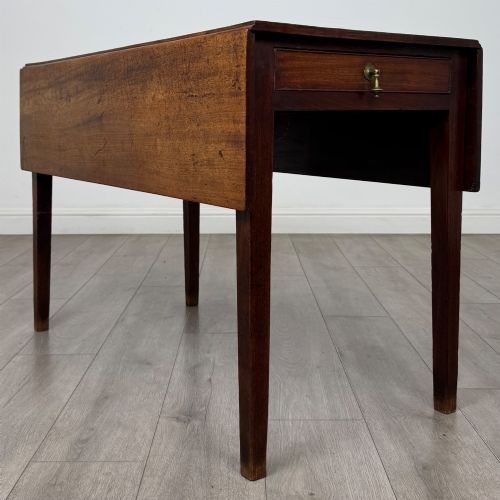 fig 7. A 19th-century Georgian style dark mahogany Pembroke side table with drop leaves, tapered square legs, and a single frieze drawer with a brass drop handle.