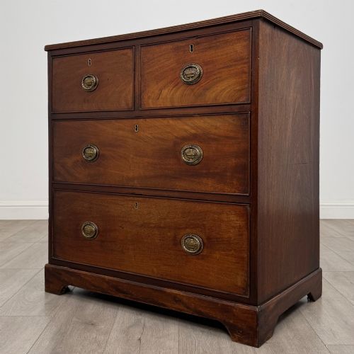 fig 1. An eighteenth-century Georgian mahogany chest of drawers featuring two short upper drawers above two long lower drawers with oval brass handles.