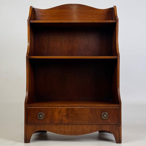 fig 1. A small 20th-century mahogany open bookcase with a shaped top gallery, two open shelves, and a single lower drawer fitted with brass ring handles.