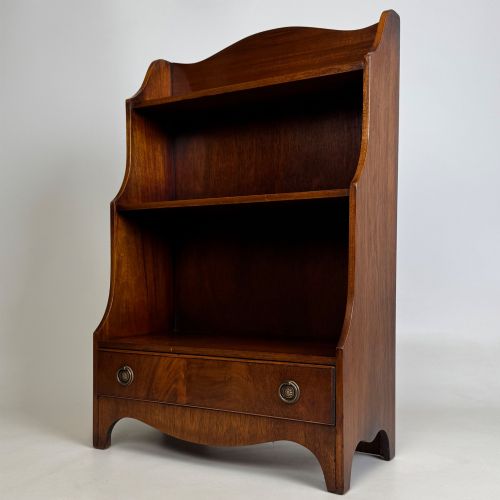 fig 2. A small 20th-century mahogany open bookcase with a shaped top gallery, two open shelves, and a single lower drawer fitted with brass ring handles.