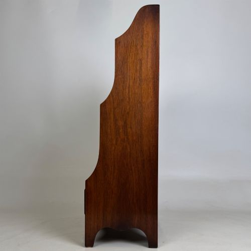 fig 3. A small 20th-century mahogany open bookcase with a shaped top gallery, two open shelves, and a single lower drawer fitted with brass ring handles.