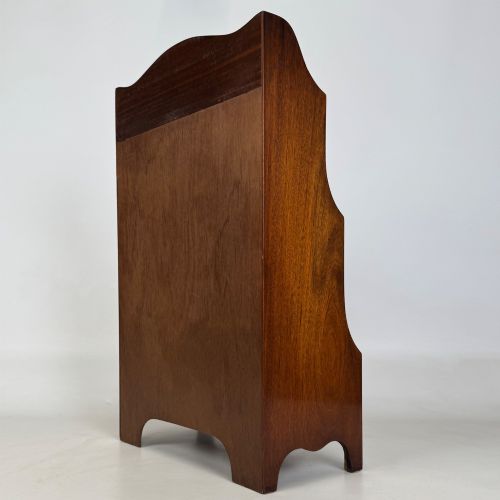 fig 6. A small 20th-century mahogany open bookcase with a shaped top gallery, two open shelves, and a single lower drawer fitted with brass ring handles.