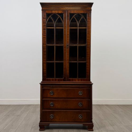 fig 1. A tall Georgian style mahogany bookcase featuring two glazed doors with gothic arch tracery above a lower section with three drawers.