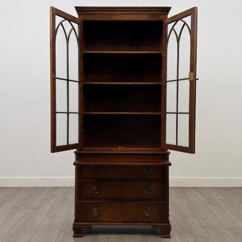 fig 2. A tall Georgian style mahogany bookcase featuring two glazed doors with gothic arch tracery above a lower section with three drawers.