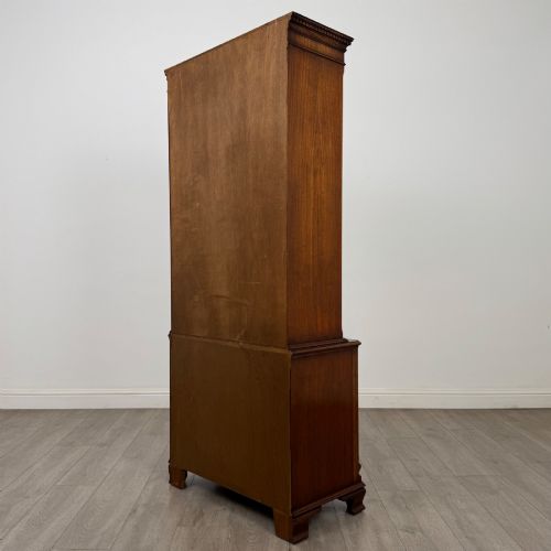 fig 7. A tall Georgian style mahogany bookcase featuring two glazed doors with gothic arch tracery above a lower section with three drawers.