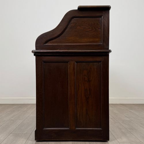 fig 3. An Edwardian dark oak roll top desk featuring a slatted tambour front above a twin pedestal base with eight drawers.