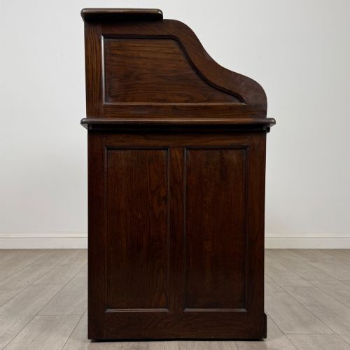 fig 7. An Edwardian dark oak roll top desk featuring a slatted tambour front above a twin pedestal base with eight drawers.