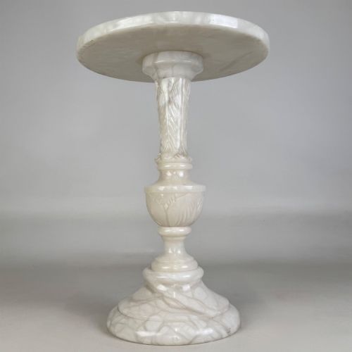 fig 1. A carved white alabaster side table featuring a circular top resting on a decorative turned pedestal stem and round base.