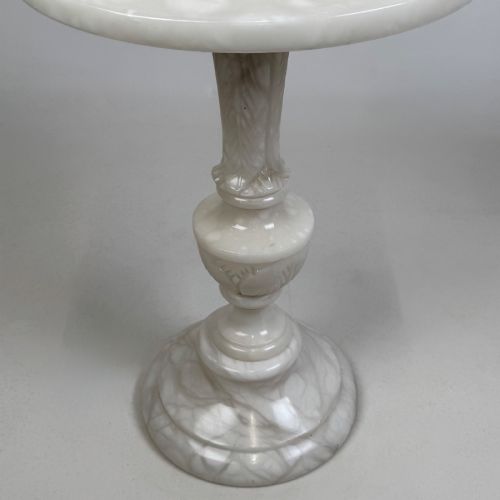 fig 4. A carved white alabaster side table featuring a circular top resting on a decorative turned pedestal stem and round base.