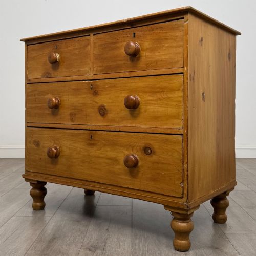 fig 1. A Victorian pine chest of drawers featuring a two over two drawer layout, turned wooden knobs, and turned feet.