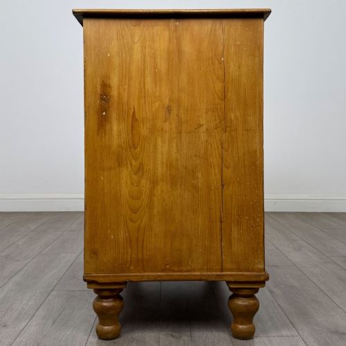 fig 6. A Victorian pine chest of drawers featuring a two over two drawer layout, turned wooden knobs, and turned feet.