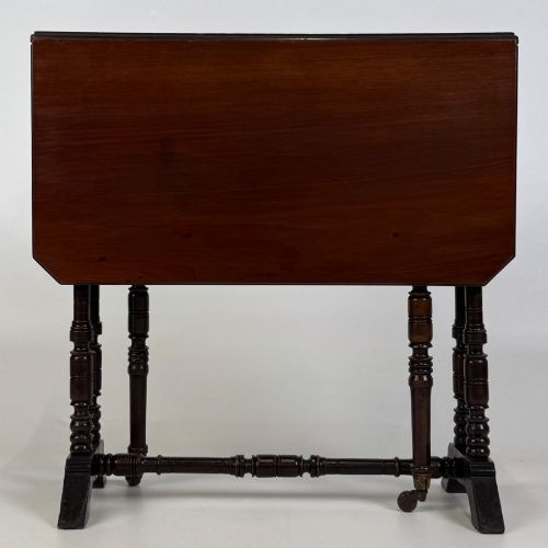 fig 1. A twentieth-century dark mahogany drop-leaf table featuring turned legs, a central stretcher rail, and folding side flaps.