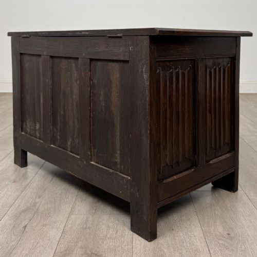 fig 5. A dark oak blanket box featuring three front panels decorated with detailed Gothic arch and shield carvings.