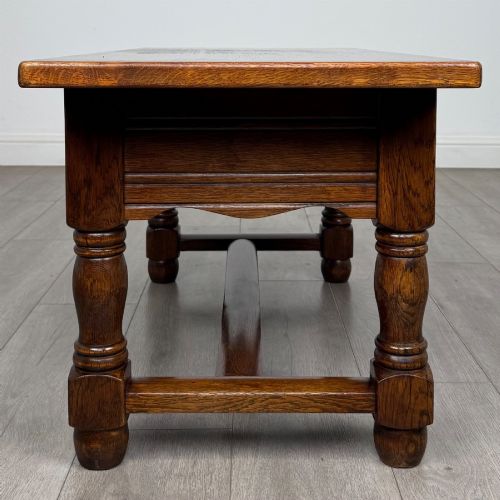 fig 2. A dark oak rectangular coffee table featuring two front drawers with wooden knob handles and turned baluster legs connected by a low stretcher.