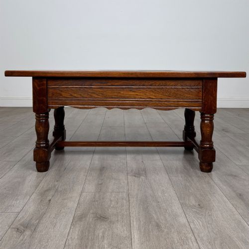 fig 4. A dark oak rectangular coffee table featuring two front drawers with wooden knob handles and turned baluster legs connected by a low stretcher.