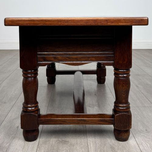 fig 6. A dark oak rectangular coffee table featuring two front drawers with wooden knob handles and turned baluster legs connected by a low stretcher.
