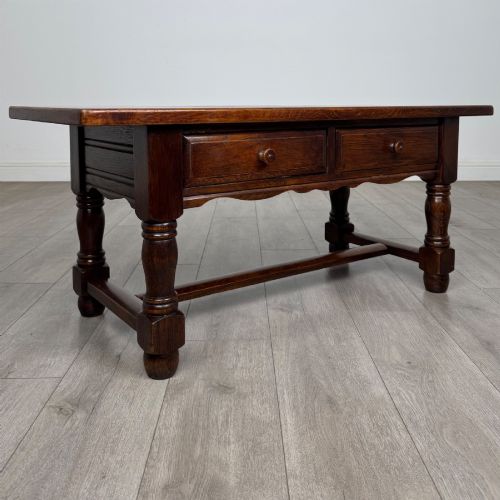 fig 7. A dark oak rectangular coffee table featuring two front drawers with wooden knob handles and turned baluster legs connected by a low stretcher.