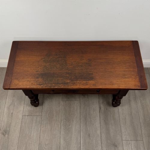 fig 8. A dark oak rectangular coffee table featuring two front drawers with wooden knob handles and turned baluster legs connected by a low stretcher.
