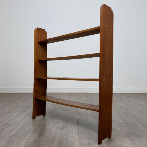 fig 1. An open-backed 20th-century Arts and Crafts walnut bookcase with four horizontal shelves and notched top end supports.