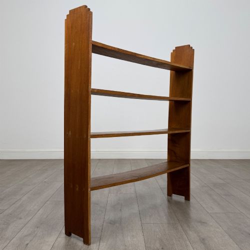 fig 3. An open-backed 20th-century Arts and Crafts walnut bookcase with four horizontal shelves and notched top end supports.