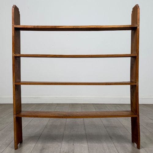 fig 4. An open-backed 20th-century Arts and Crafts walnut bookcase with four horizontal shelves and notched top end supports.