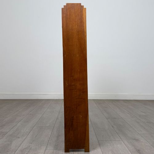 fig 6. An open-backed 20th-century Arts and Crafts walnut bookcase with four horizontal shelves and notched top end supports.