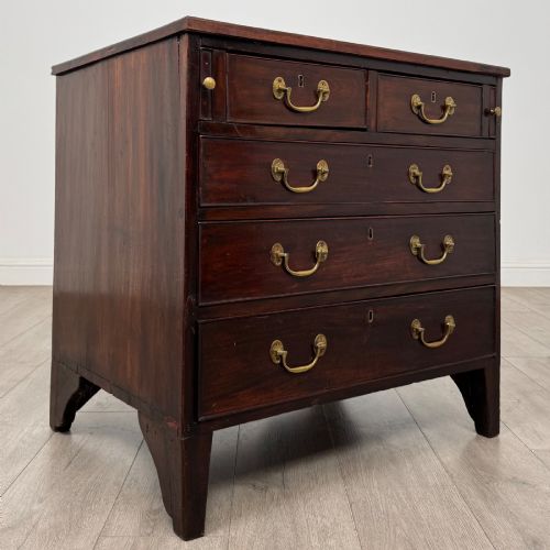 fig 7. An 18th-century Georgian dark mahogany chest of drawers with two short drawers over three long drawers and brass swan-neck handles.